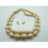 A two strand graduated ivory bead necklace and a pair of 9ct gold earrings set with ivory