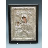 A white metal icon with decoration in relief,