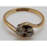 An 18ct gold ring set with two diamonds in a twist setting,