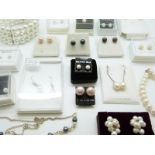 A collection of pearl items, including a silver necklace set with pearls, bracelet,