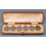 A cased set of Edward VII hallmarked silver buttons of Art Nouveau design depicting a lady playing