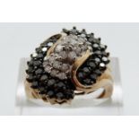 A 9ct gold ring set with clear and black diamonds in a cluster, size P, 5.