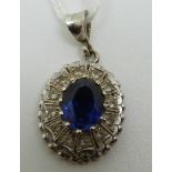 An 18ct white gold pendant set with an oval sapphire surrounded by paste