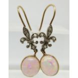 A pair of Victorian earrings set with an opal cabochon and diamonds in the form of a fleur de lys,