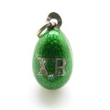 A Russian silver egg pendant set with green enamel, 'XB' to one side and a seed pearl to the other,