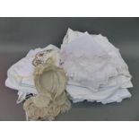 A collection of linen to include Edwardian petticoats, aprons, bonnets etc,