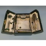 An Edward VII leather cased travelling vanity case fitted with five hallmarked silver topped