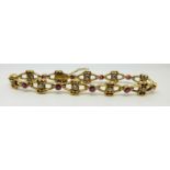 A French 18ct gold bracelet set with alternating round cut diamonds and rubies in a stylised bow