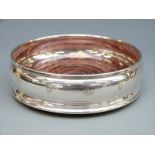 A hallmarked silver wine coaster with feature millennium hallmarks,