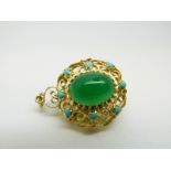 An 18ct gold pendant set with a large green cabochon to each side surrounded by further turquoise