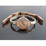A 9ct gold ladies wristwatch with Arabic numerals, two-tone silver and gold face, blued hands,
