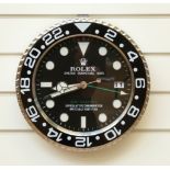 Rolex advertising wall clock with black chronometer style dial and date aperture.