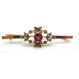 A 9ct gold ring set with red paste surrounded by seed pearls, 3.