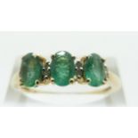 A 9ct gold ring set with three oval emeralds and diamonds, size R/S, 2.