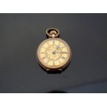 A 9ct gold ladies keyless winding open faced pocket watch with engraved self coloured face,