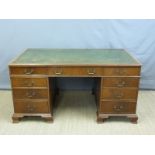 A twin pedestal mahogany desk with leather inset top and fitted with nine drawers,