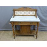 A marble topped satin walnut wash stand with tiled back,