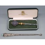 A cased hallmarked silver millennium button hook and a white metal handled button hook marked