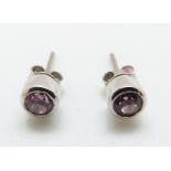 A pair of 18ct white gold earrings set with pink sapphire to each