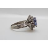 A platinum ring set with a cushion cut natural cornflower blue sapphire of approximately 5.