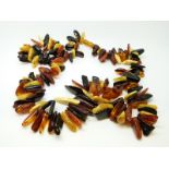 An amber necklace of irregular shaped pieces of various colours, 92g, 59cm long.