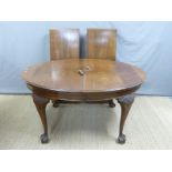 A late 19thC/early 20thC oval mahogany wind out extending dining table with two leaves,