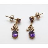 A pair or 9ct gold earrings set with amethysts