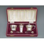 A cased Art Deco style hallmarked silver three piece cruet set,