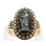 An early Victorian ring set with a hardstone cameo depicting a woman playing the harp,