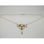 A 9ct gold Edwardian necklace set with aquamarines and seed pearls in a stylised bow design