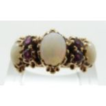 A Victorian ring set with three opal oval cabochons and four round cut rubies with foliate design