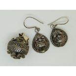 A pair of silver earrings and a silver sphere pendant with filigree decoration