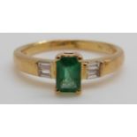 An 18ct gold ring set with an emerald cut emerald of approximately 0.