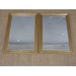 A pair of gilt framed mirrors with bevelled glass,
