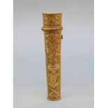 An 18thC gilt metal bodkin case with relief decoration of a jester or acrobat on a pedestal,