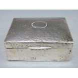 A George V hallmarked silver cigarette case with Arts & Crafts style hammered decoration,