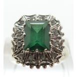 An 18ct white gold ring set with a faux emerald cut emerald surrounded by paste, size Q, 5.