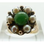 A 14k gold ring set with a jade cabochon surrounded by pearls, size K, 4.