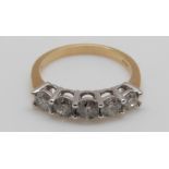 An 18ct gold ring set with five diamonds, the centre diamond approximately 0.