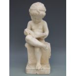 An alabaster figure of a boy reading a book,