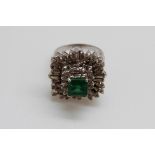 An 18ct white gold ring set with a square cut emerald of approximately 1ct surrounded by baguette
