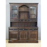 A stained pine dresser with glazed cupboards and four drawers to top,