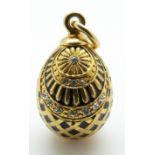 A silver gilt egg pendant set with paste and black enamel,