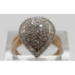 A 9ct gold ring set with round cut diamonds within a border of baguette cut diamonds in a pear