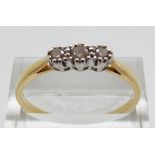 An 18ct gold ring set with three diamonds, size W,