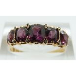 A 15ct gold ring set with five graduated garnets and diamonds (Birmingham 1873), size R/S, 3.