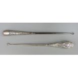 Two long hallmarked silver handled button hooks,