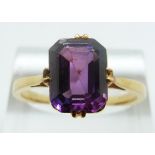 A yellow metal ring set with an emerald cut synthetic purple sapphire, size R/S, 4.