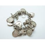 A silver charm bracelet with coin charms, silver heart, dog, cow,