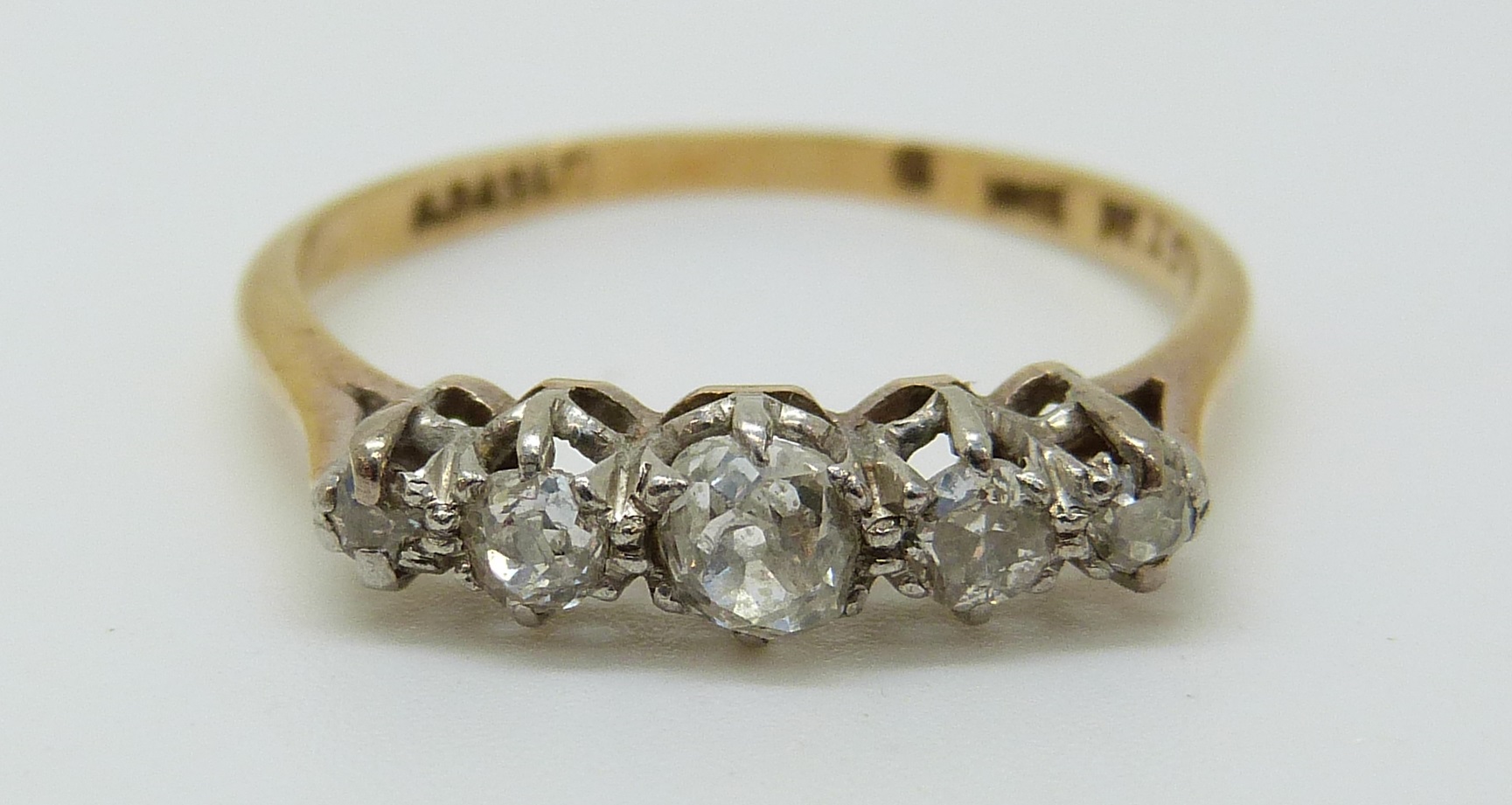 An 18ct gold ring set with five old cut diamonds in a platinum setting,